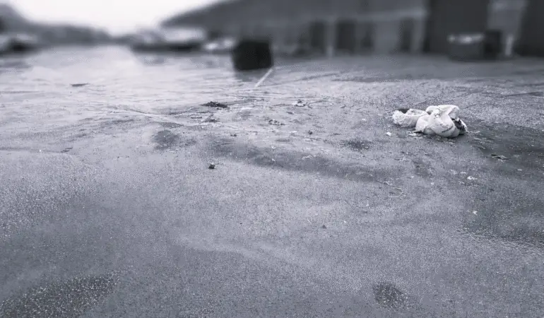 Heavy sand and debris buildup on parking lot surface after winter in Durham Region