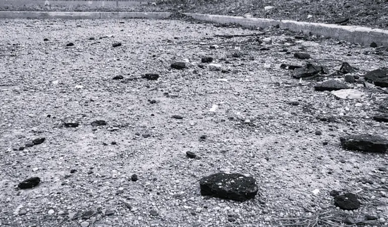 Excessive sand and debris buildup on Toronto parking lot surface after winter sanding